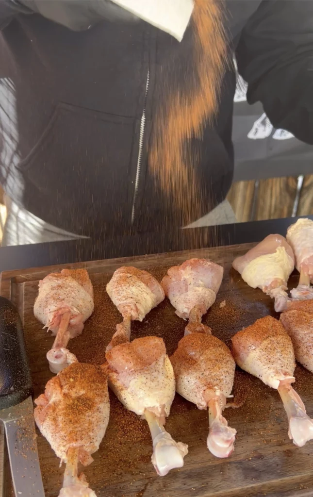 bacon wrapped chicken lollipops being seasoned