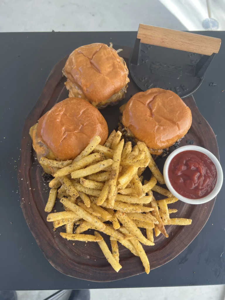 mash burgers with fries and ketchup on the cutting board