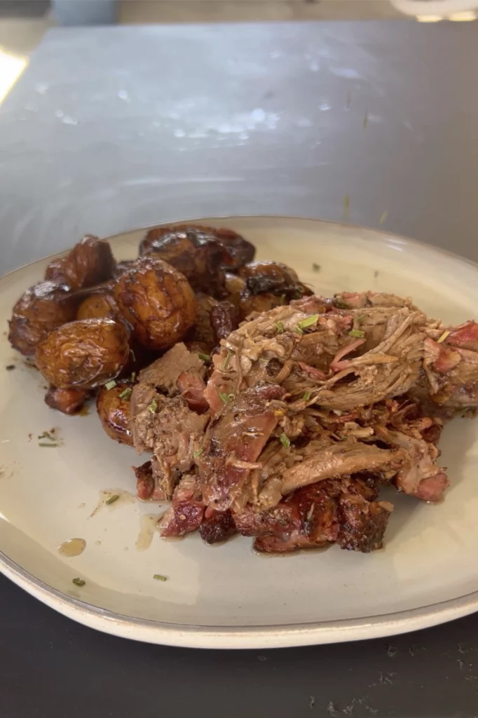 roasted leg of lamb and potatoes on a plate
