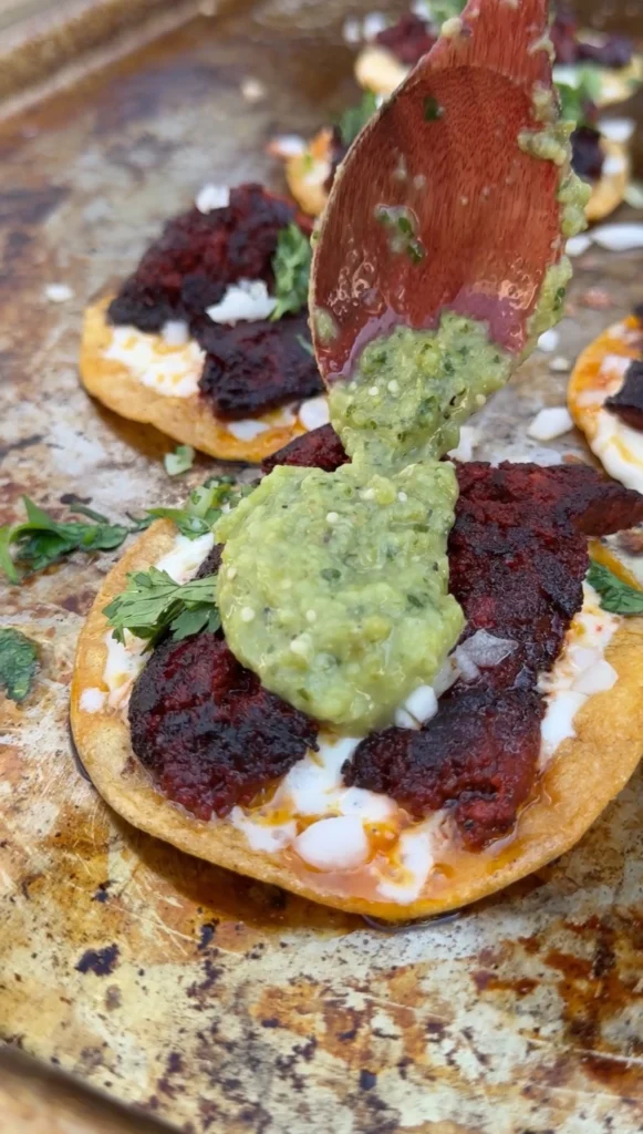 garnishing the tacos on a pan