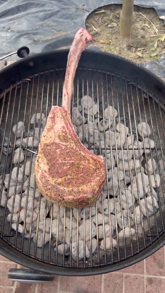 reverse searing a tomahawk ribeye on a charcoal grill