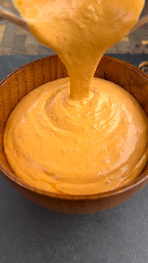 smoky chipotle mayo being poured in a bowl