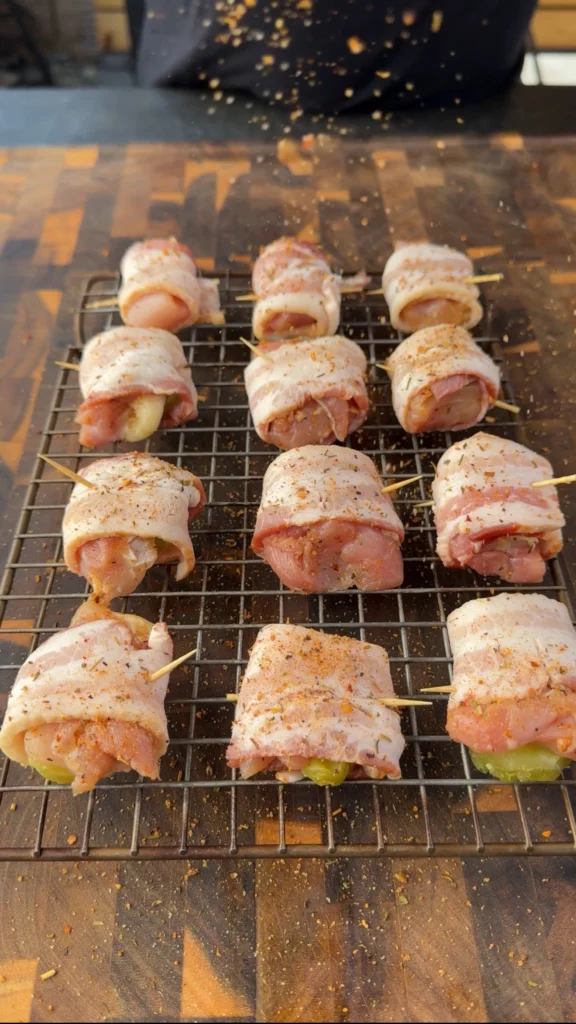 Bacon wrapped chicken and pickle bites secured with toothpicks on a tray