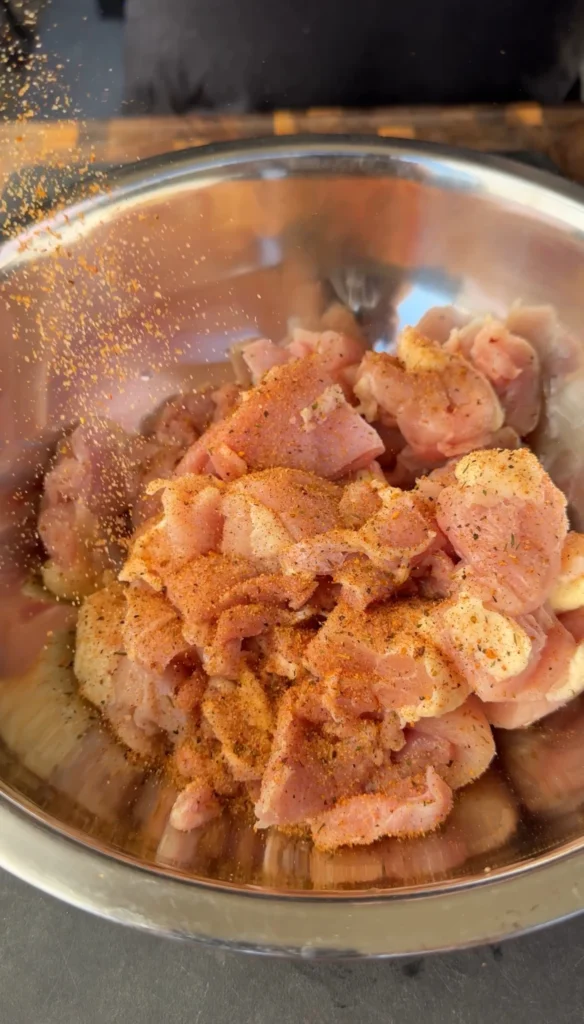 Cut seasoned chicken thigh pieces in a mixing bowl ready for wrapping