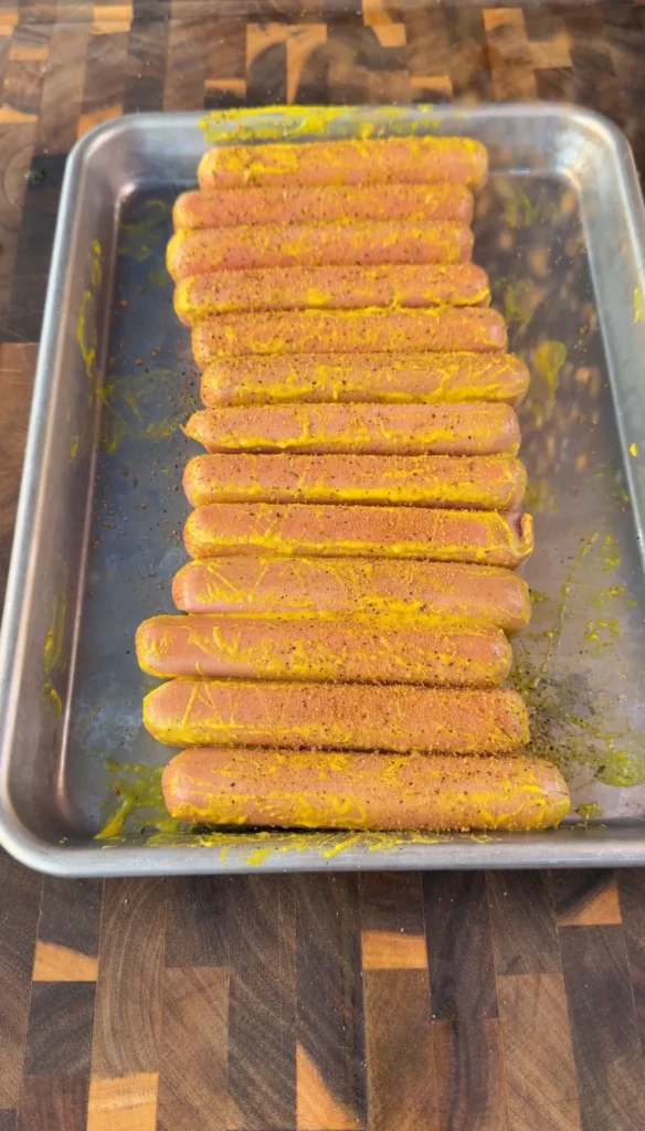 Dusting sweet BBQ seasoning over cross-cut hotdog pinecones