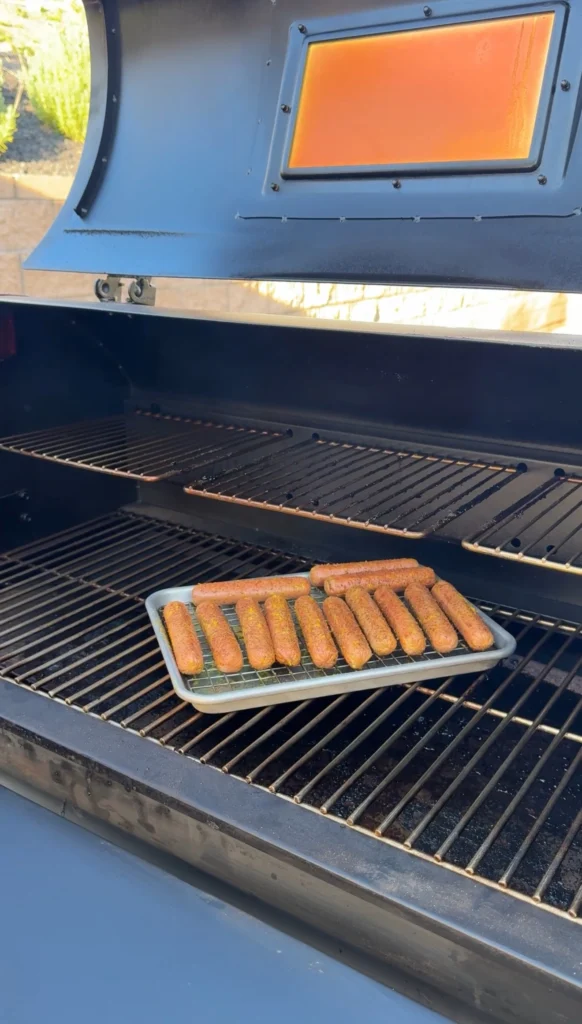 Hotdog pinecones arranged on a wire rack going onto the smoker