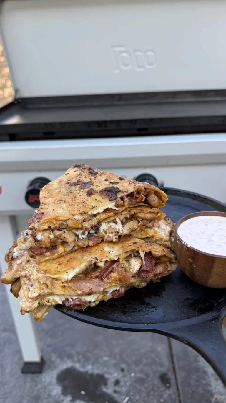 Bacon chicken chipotle ranch quesadillas cut into wedges on black plate with creamy chipotle ranch dipping sauce, showing golden crispy tortilla exterior