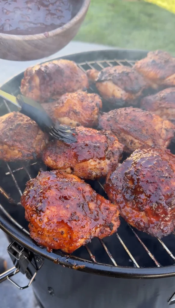 Honey chipotle chicken thighs on round grill grates with caramelized glaze, showing final grilling stage and perfect caramelization