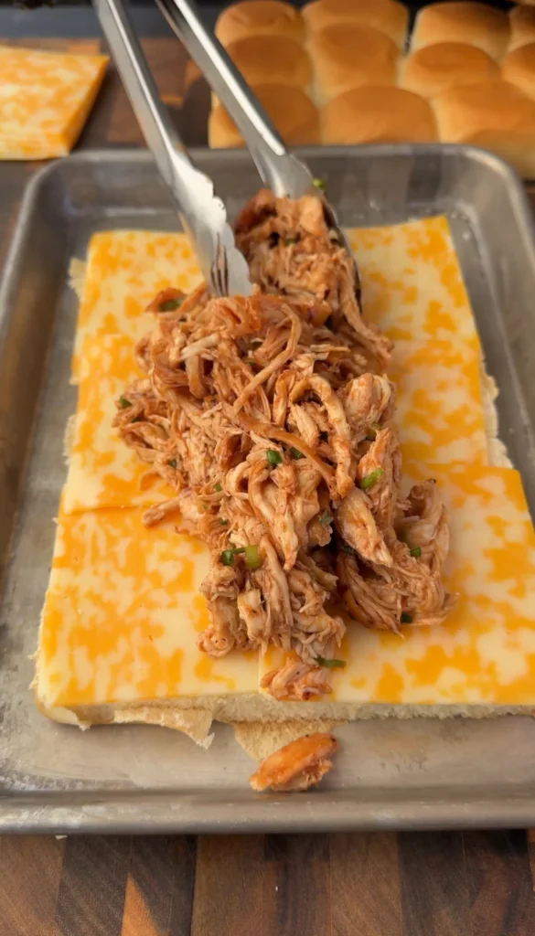 sliders being assembled with the chicken on top of the cheese