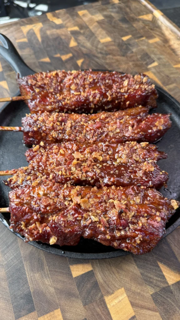 pork belly on a stick on a cutting board