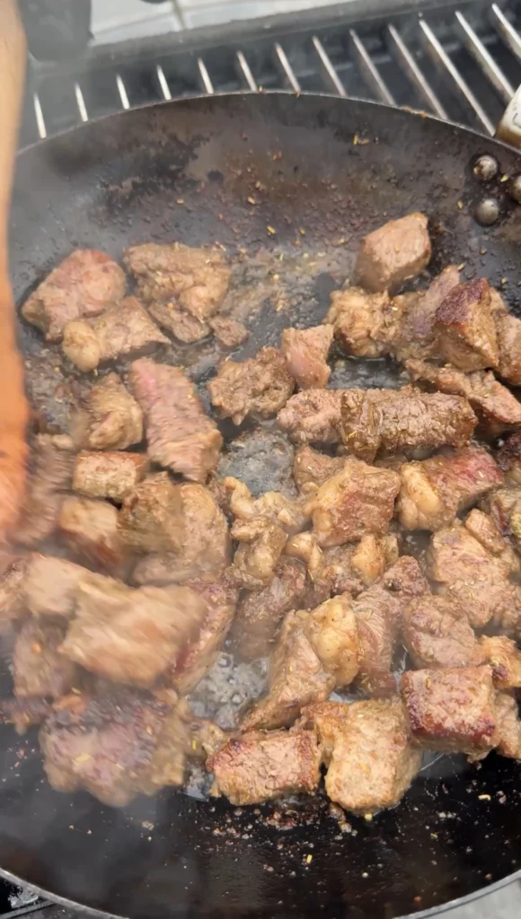 steak being cooked in the cast iron skillet