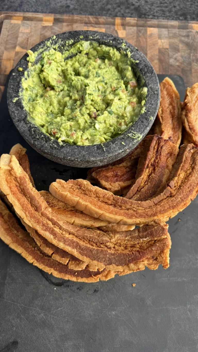 fried chicharrónes on a plate with guac