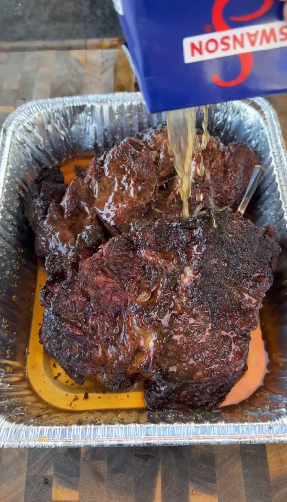 chuck roast getting drenched with beef stock