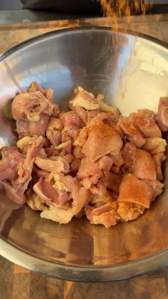 chicken thighs in a bowl with seasoning