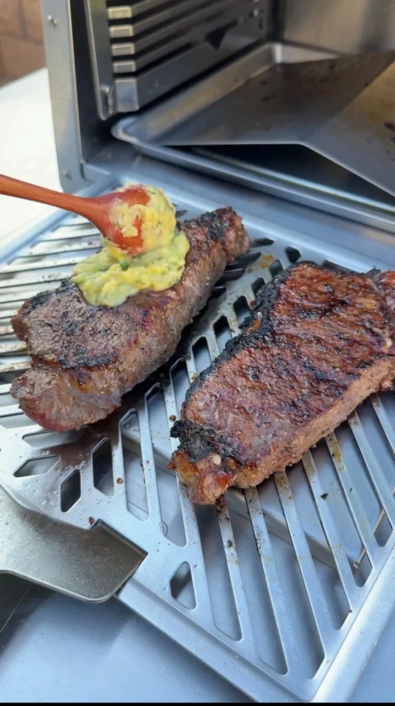 adding the compound butter to steaks before infrared  