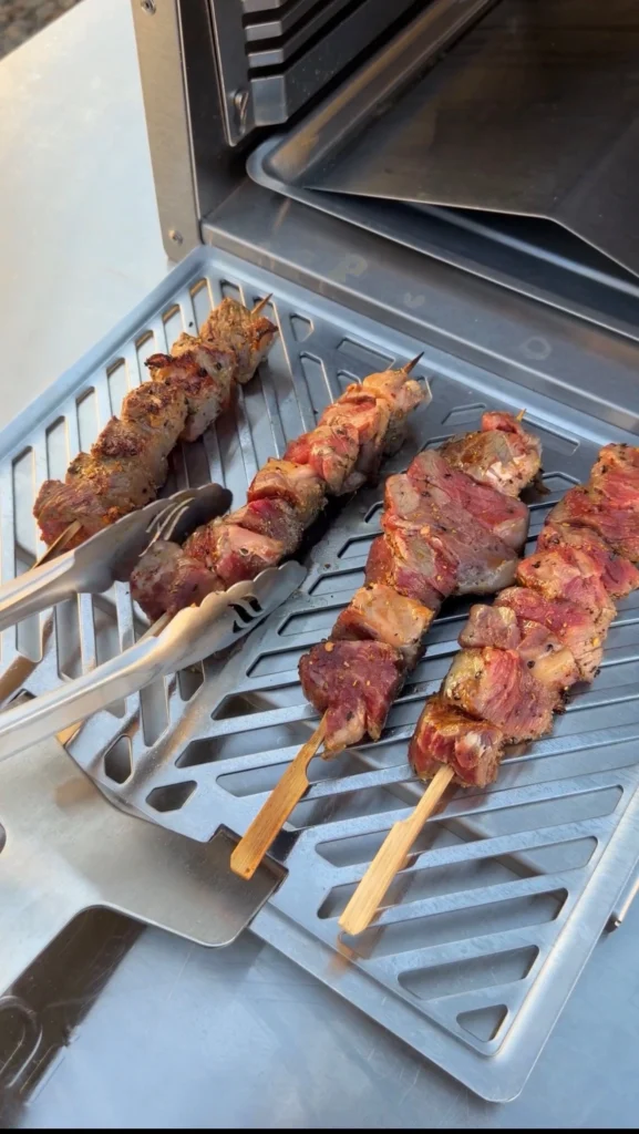 cooking the steak bites on skewers