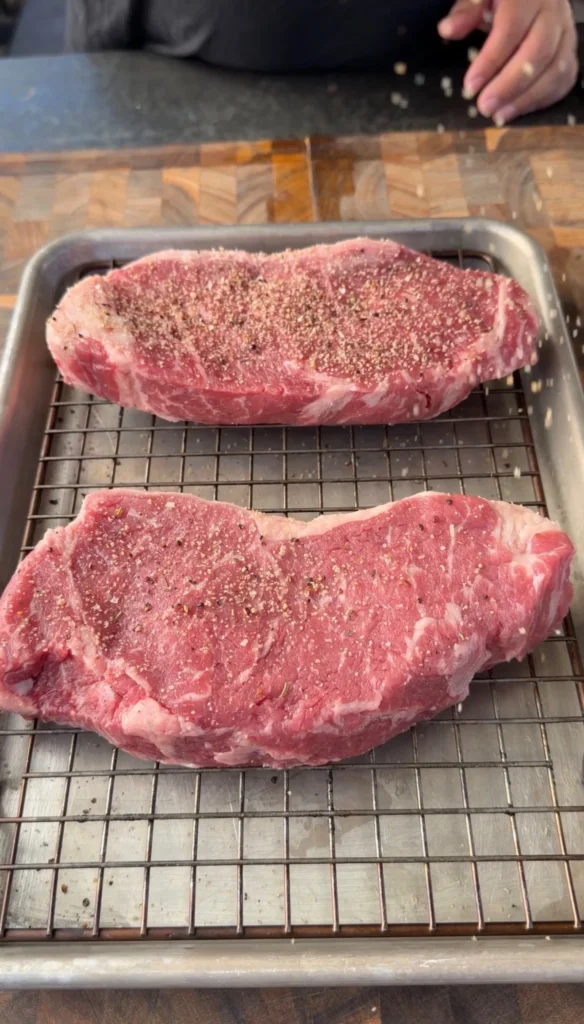 seasoned new york strips on a rack