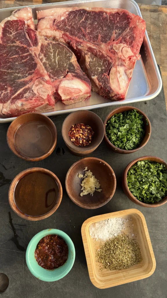 porterhouse steaks on a tray with ingredients