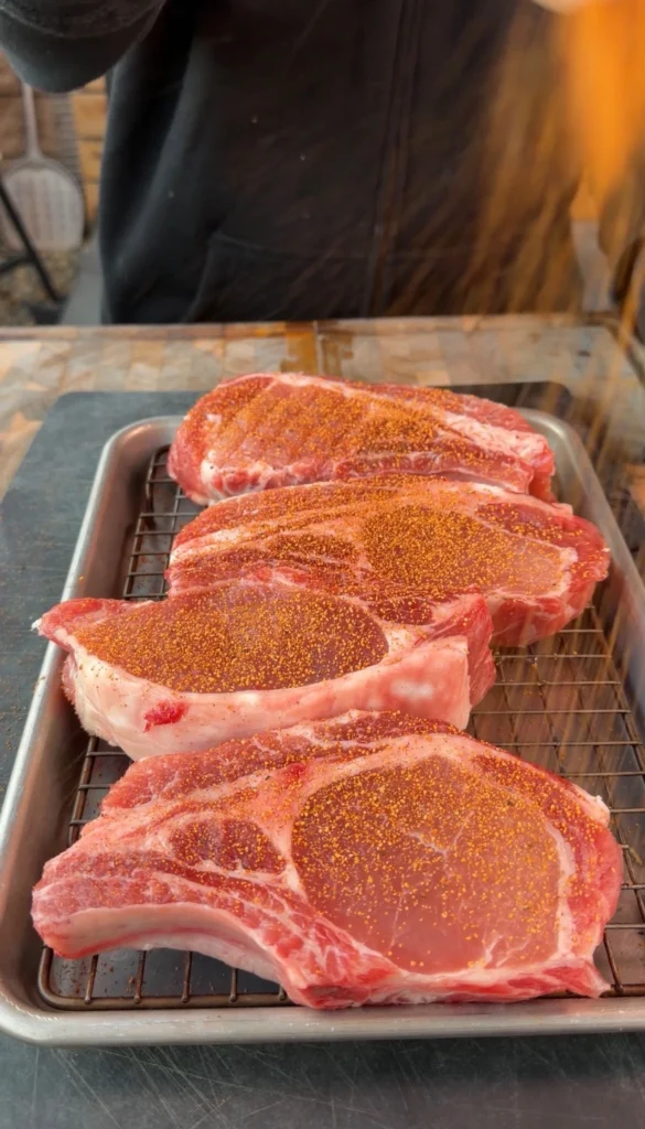 seasoned pork chops on a silver tray