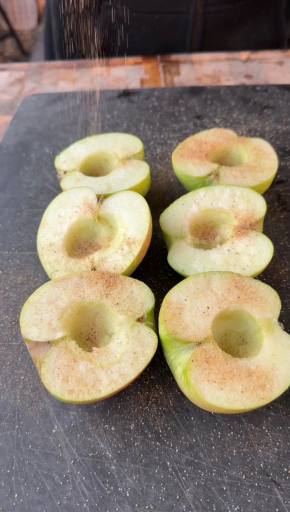 cut and seasoned apples on a Black cutting board 