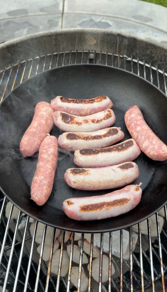 seared brats on a cast iron skillet