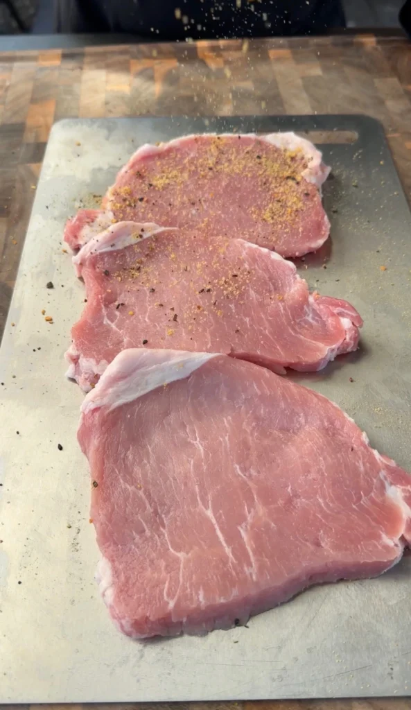 seasoned pork chops on the cutting board