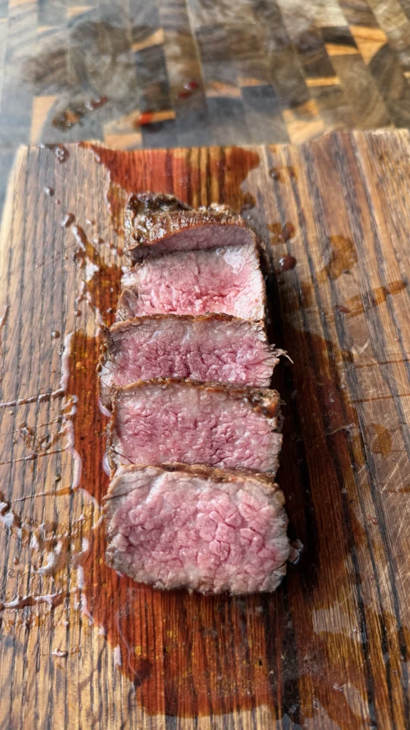 sliced tri tip on a wooden cutting board