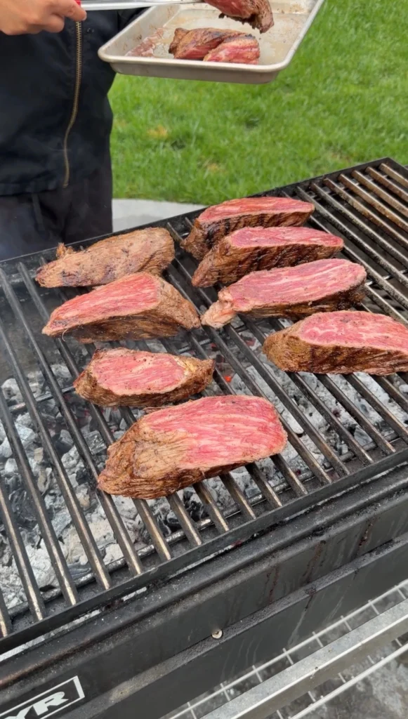 sliced tri tip on the grill grates