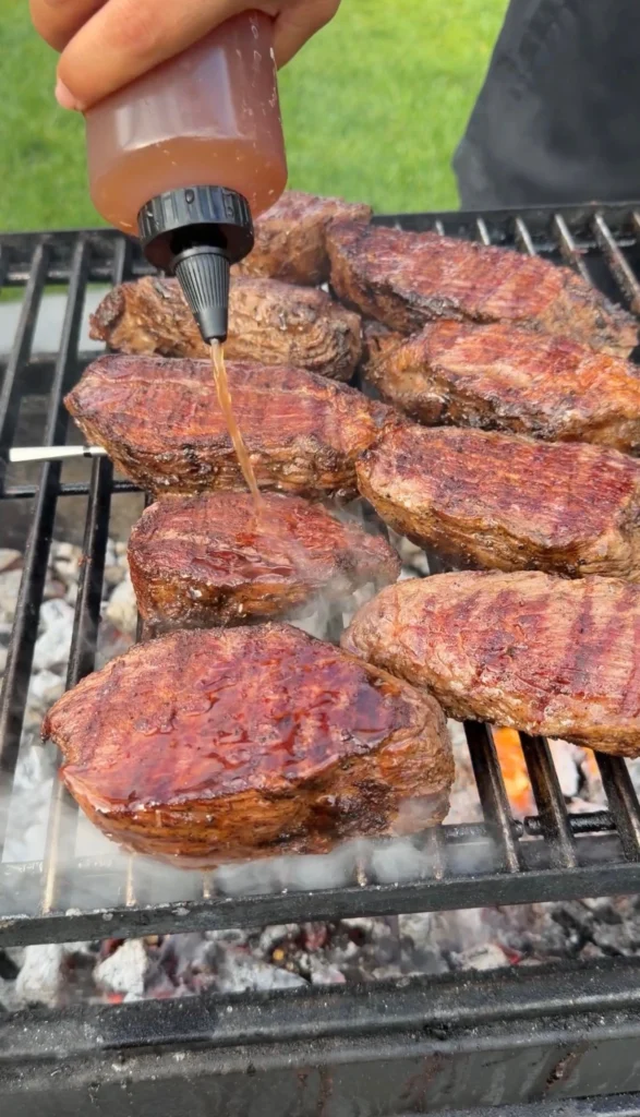 flipped steaks on open coals