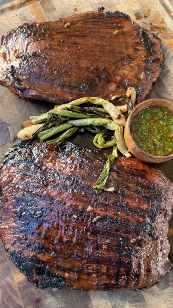 perfectly cooked flank steak on a cutting board