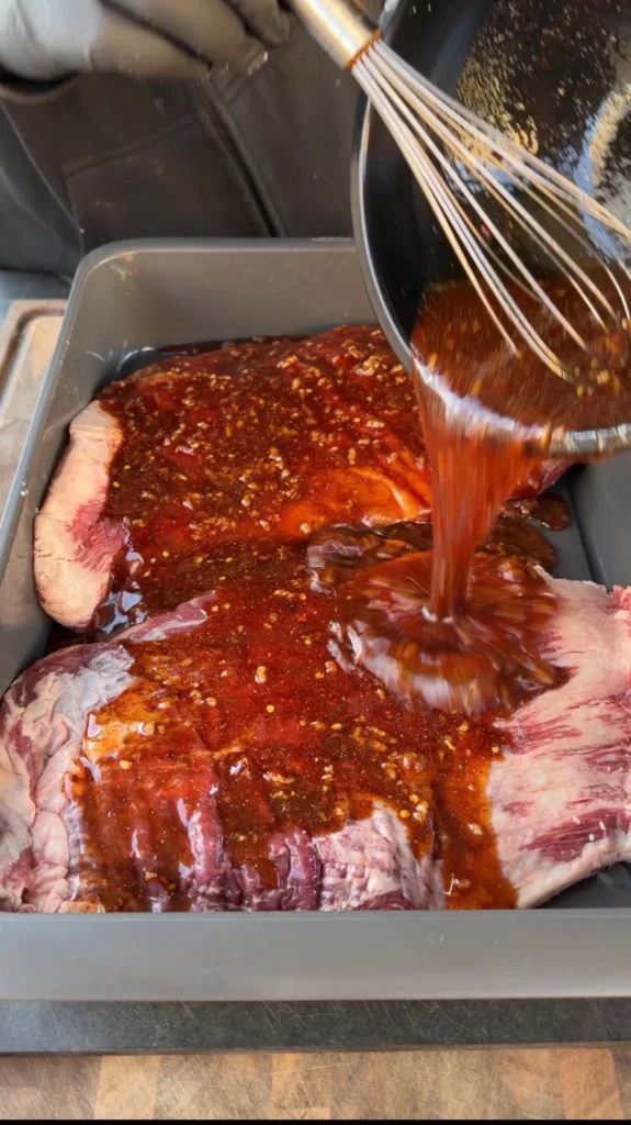 flank steaks in a bowl with the marinade