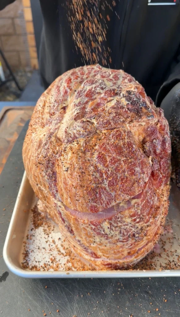 seasoned spiral ham on a metal cooking tray