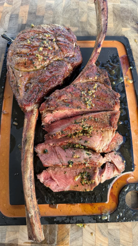 sliced tomahawk ribeye on a cutting board