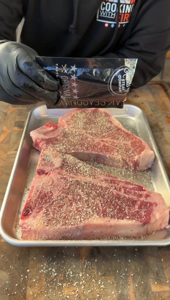 seasoned porterhouses on a metal tray 