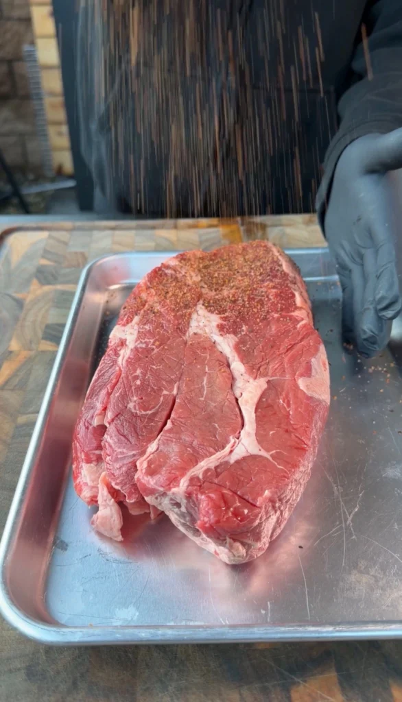 seasoned chuck roast on a metal tray