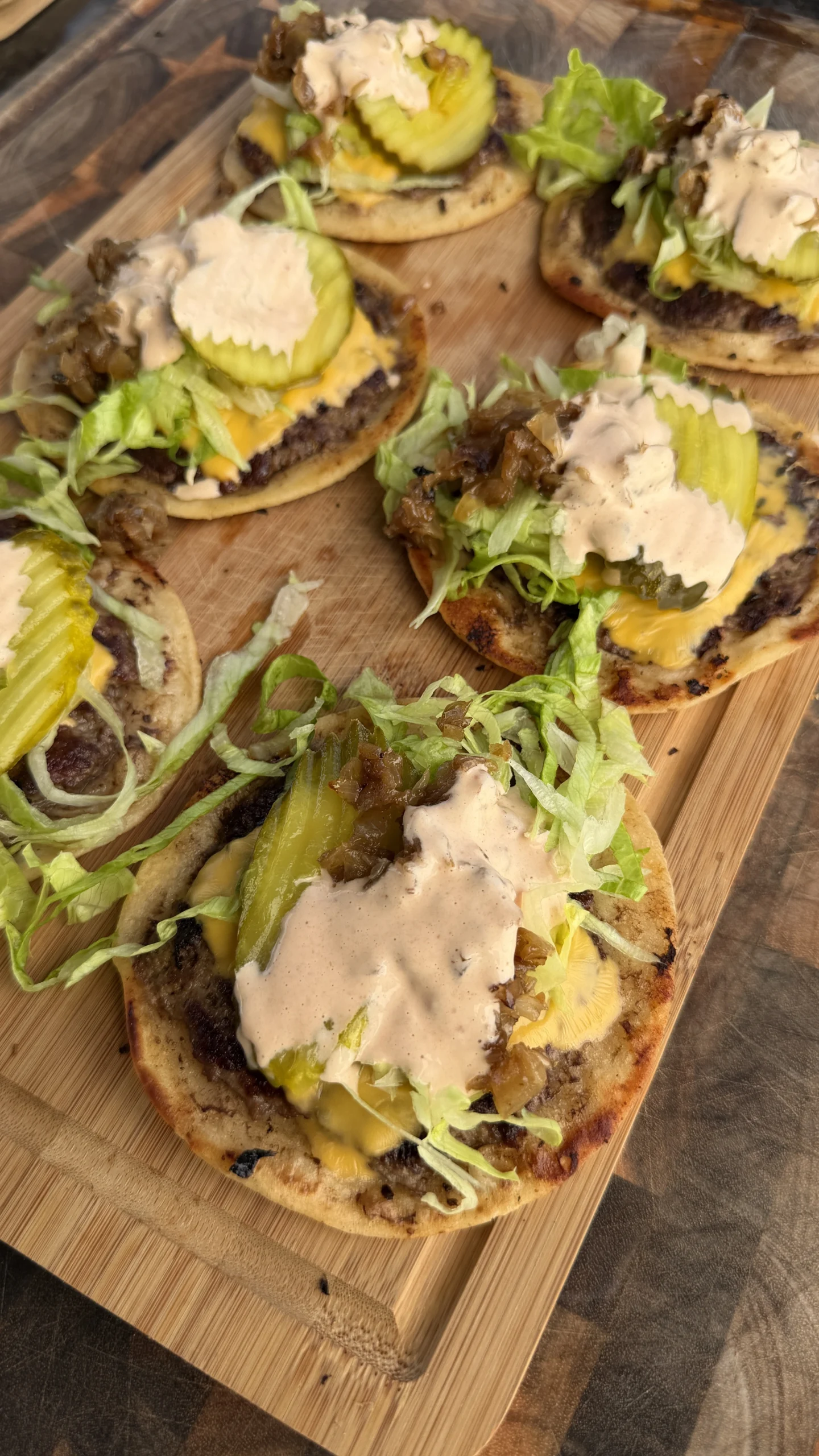 tacos-chipotle-mayo-plated.webpSpicy smash burger tacos topped with pepper jack cheese, lettuce, onion, and chipotle mayo drizzle