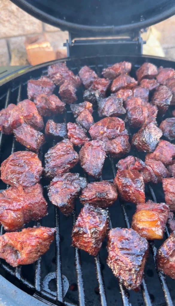 Smoked chuck roast burnt ends with deep mahogany bark on kamado grill grates