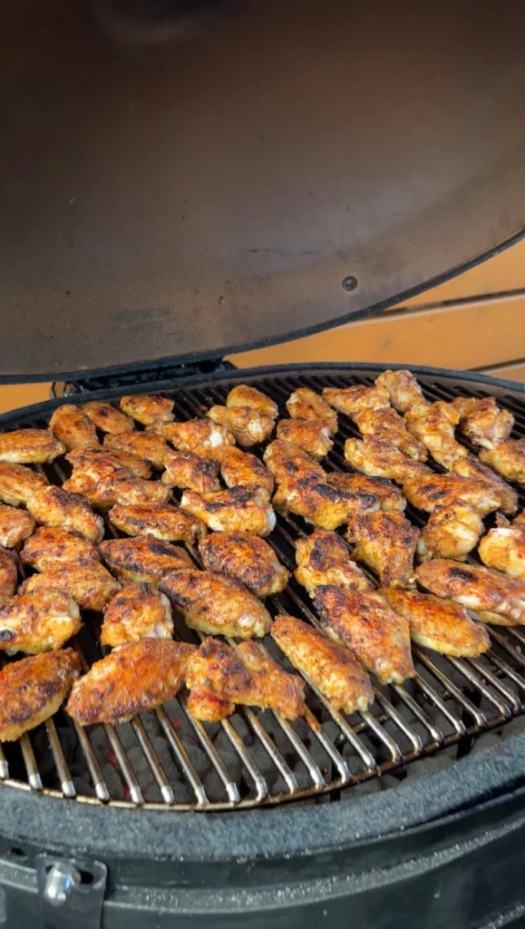 Chicken wings with deep golden char and crispy skin on a kamado grill