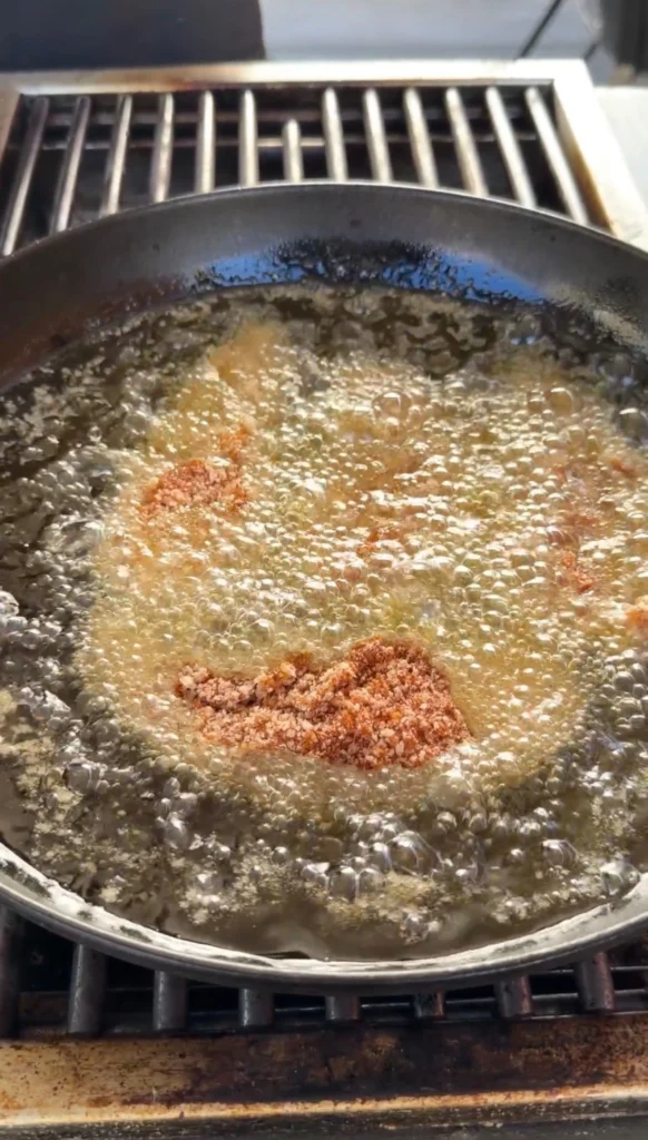 Panko-breaded chicken tenders frying in hot oil with bubbles in a skillet