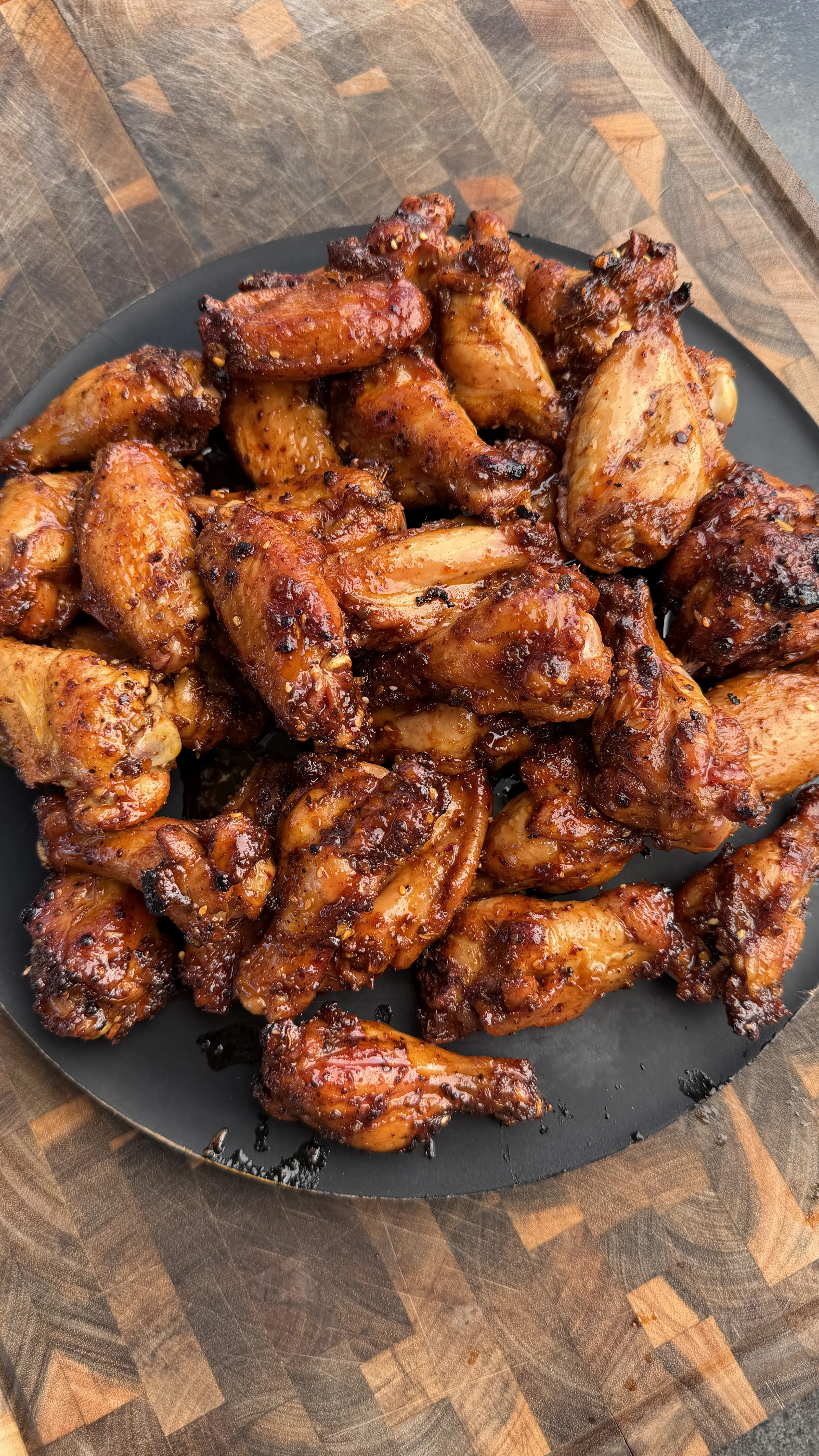 Crispy smoked chicken wings on dark plate