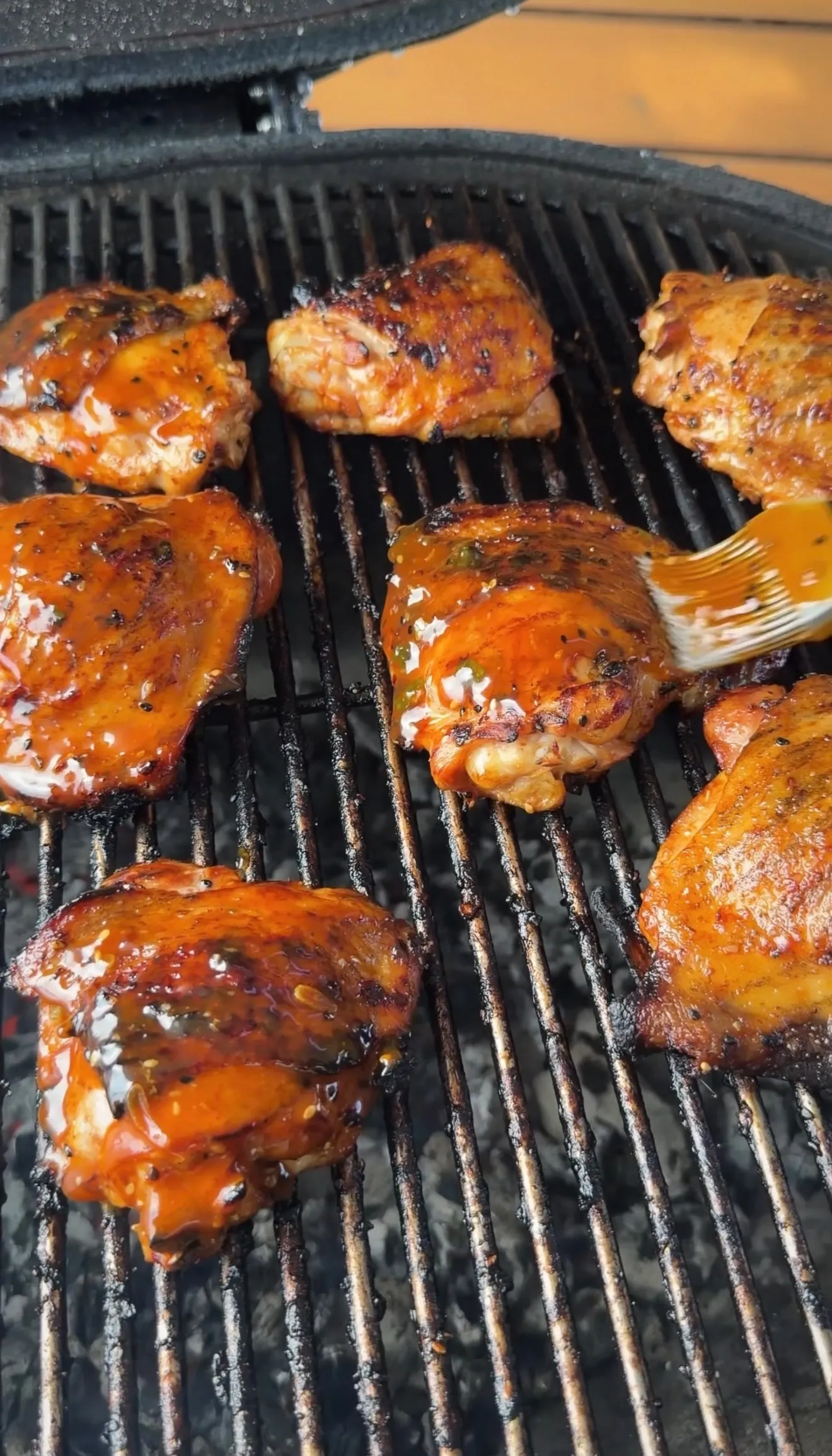 Glazed chicken thighs grilling on BBQ