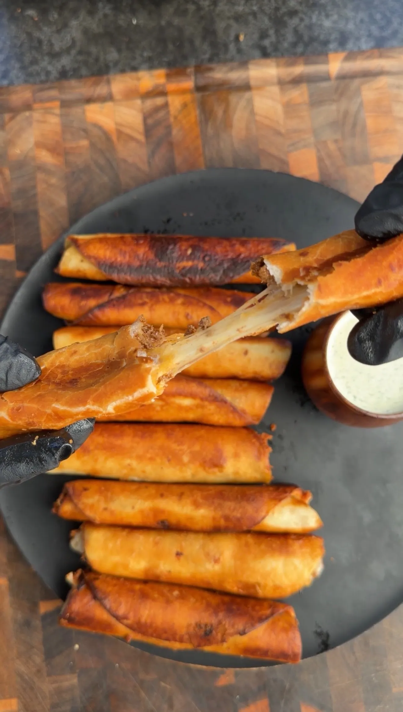 Golden cheesy beef taquitos on plate