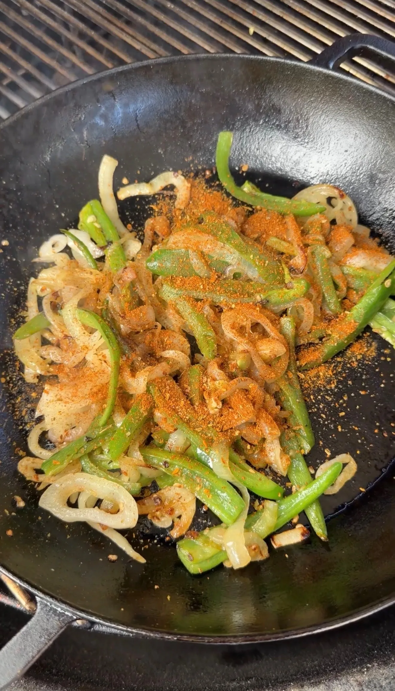 Sautéed peppers and onions in wok with seasoning