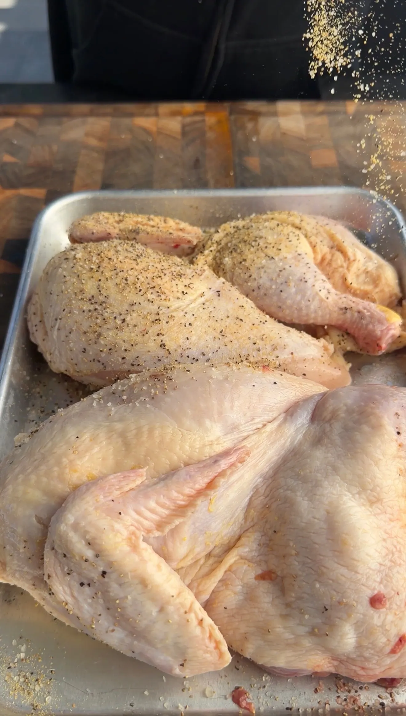 Seasoned raw chicken halves ready for smoking