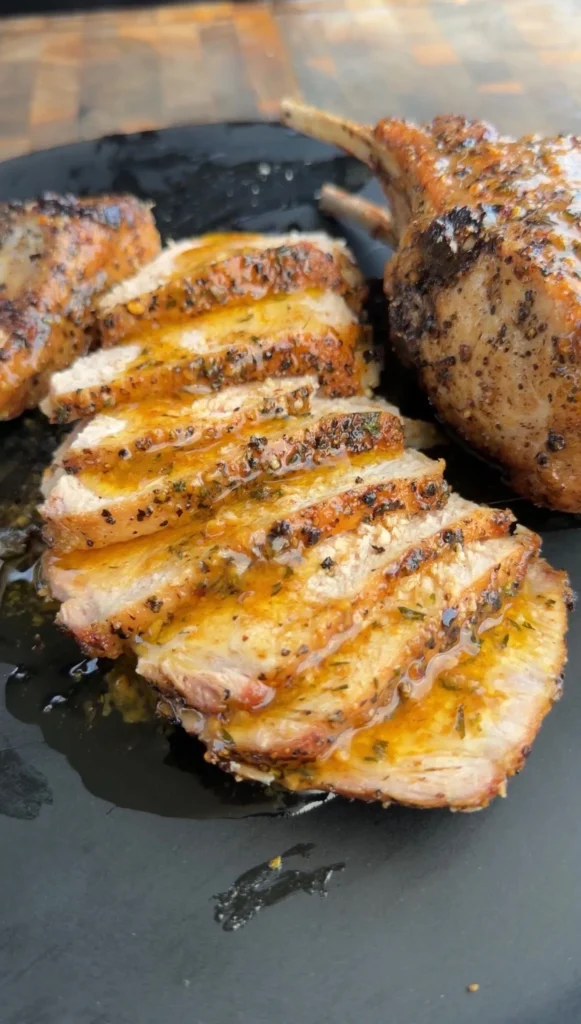 Sliced double bone pork chops with golden-brown sear in a cast iron skillet, showing juicy interior