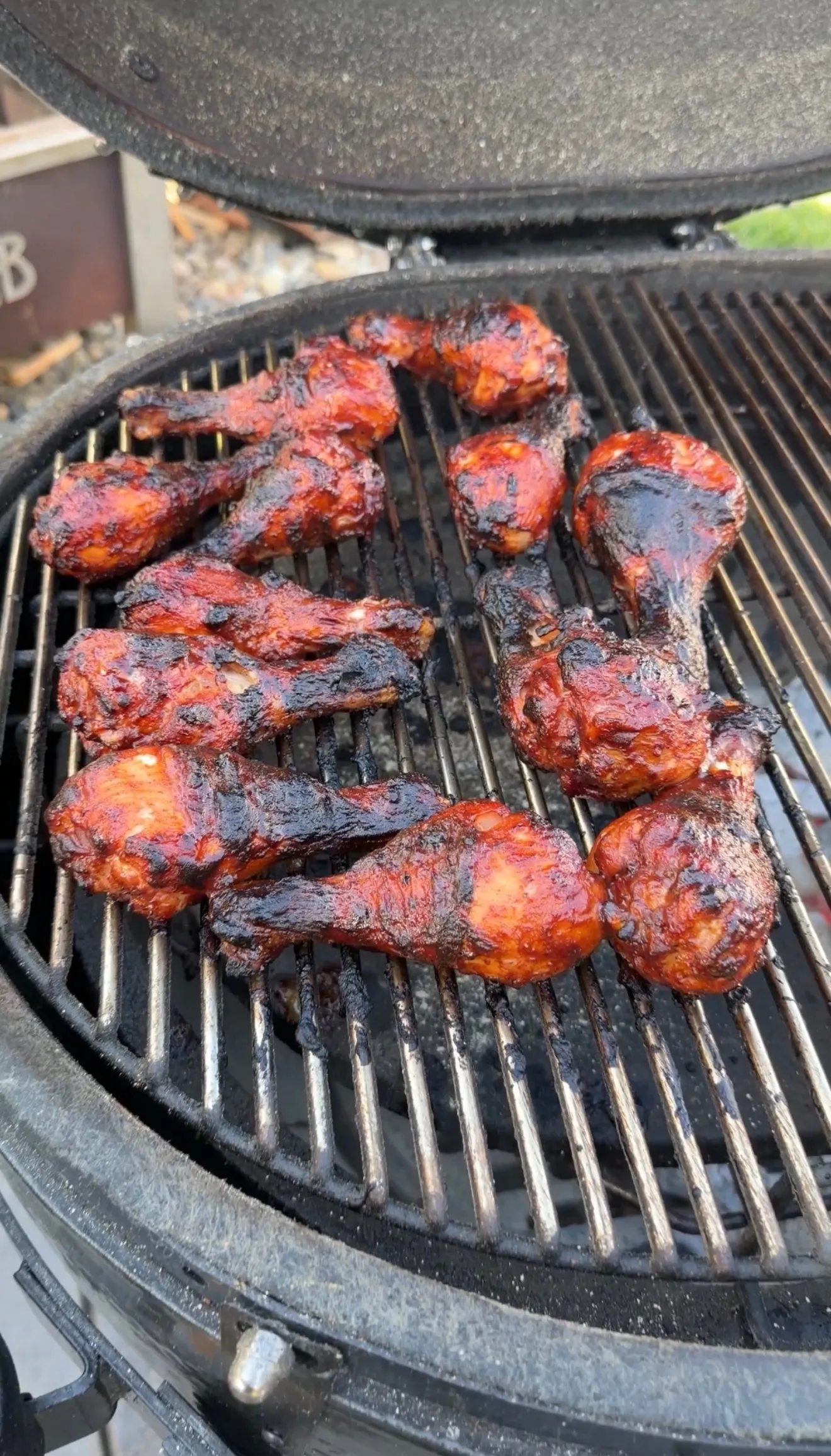 Barbecue chicken drumsticks grilling on charcoal grill