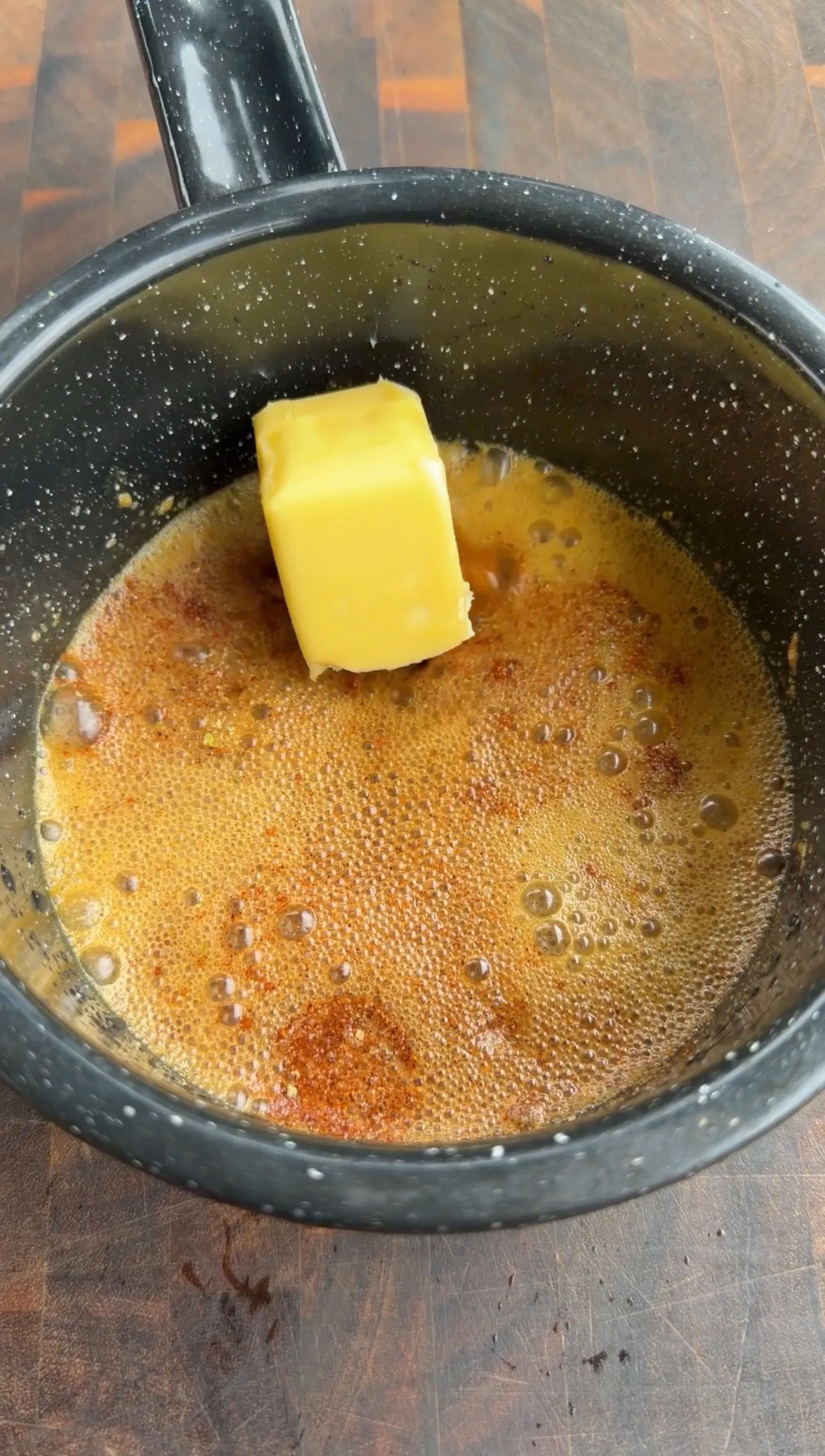 Butter melting in hot pan with beer and seasonings for beer can chicken injection marinade