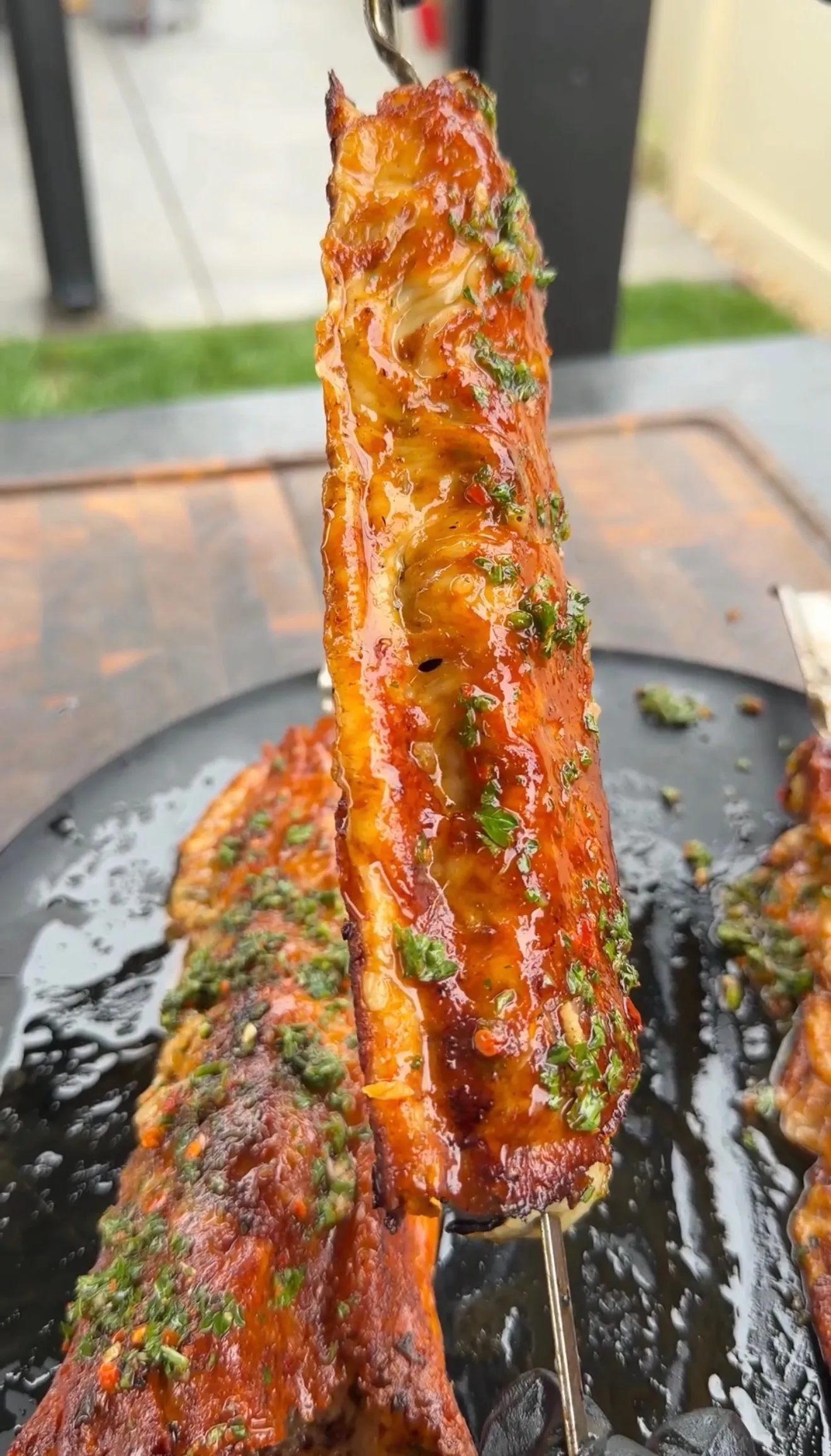 Cheese-crusted steak kebab with chimichurri being lifted from grill pan showing golden melted cheese crust