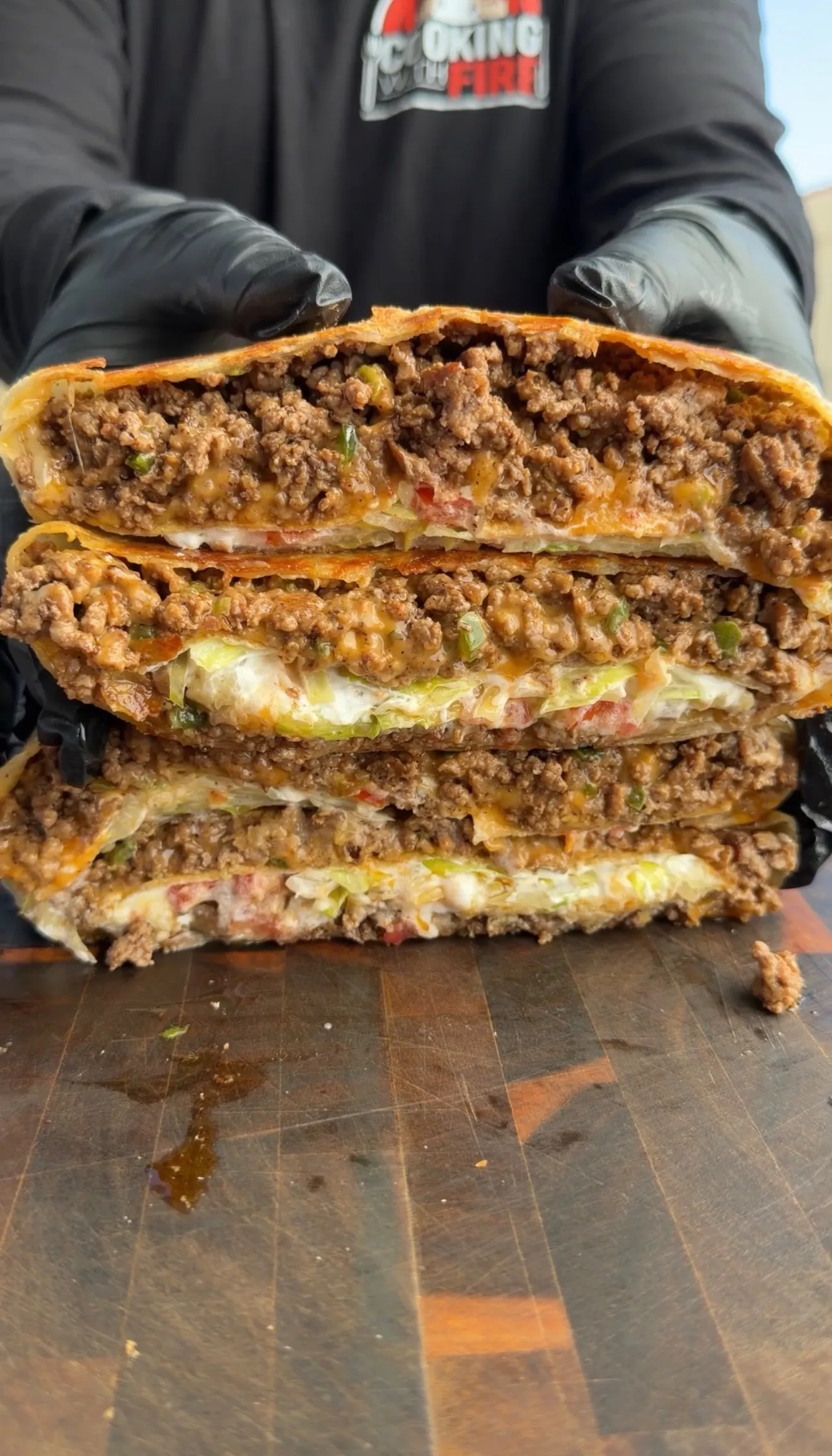 Classic crunchwrap cut in half showing layers of seasoned ground beef, lettuce, cheese, and tortilla