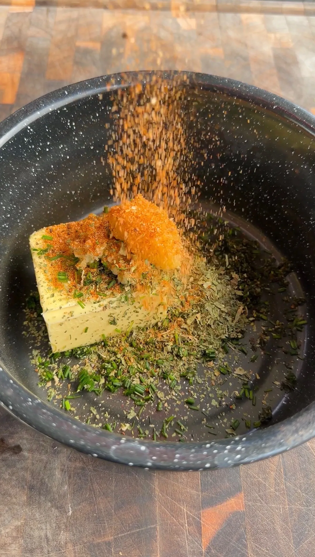 Garlic herb parmesan oysters being seasoned with butter and herbs on a sheet pan
